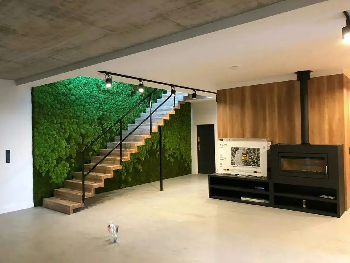 Aranżacja wnętrza: zielona ściana z mchu poduszkowego pod schodami