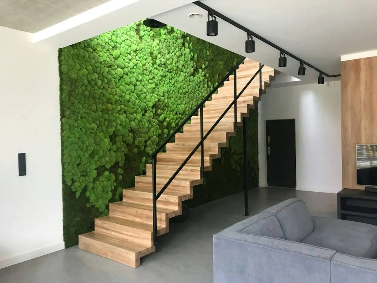 Zielona ściana z mchu poduszkowego w nowoczesnym wnętrzu wspierająca biophilic design